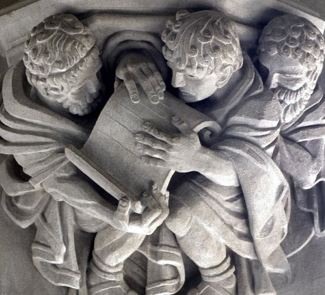 Stone Carving of Three Men Looking at a Scroll Sterling Memorial Library