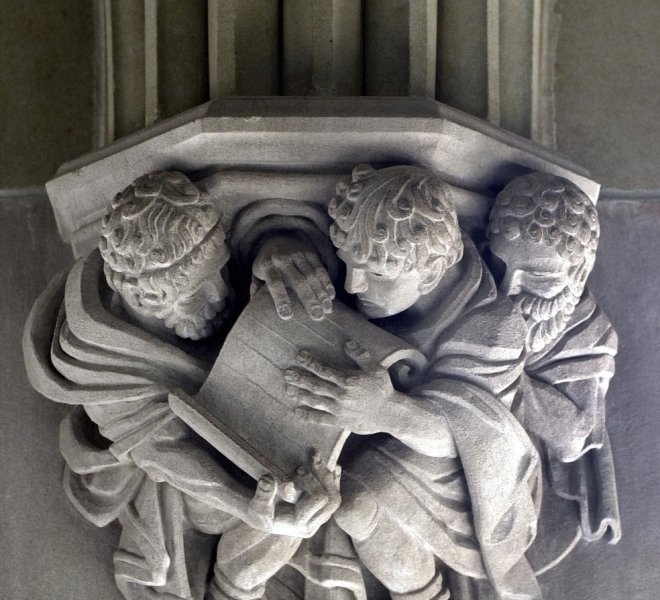 Stone Carving of Three Men Looking at a Scroll Sterling Memorial Library